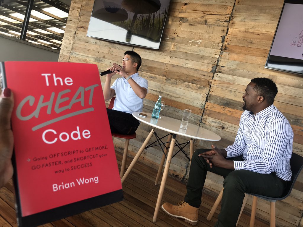 A copy of Brian Wong's book The Cheat Code in the foreground. 