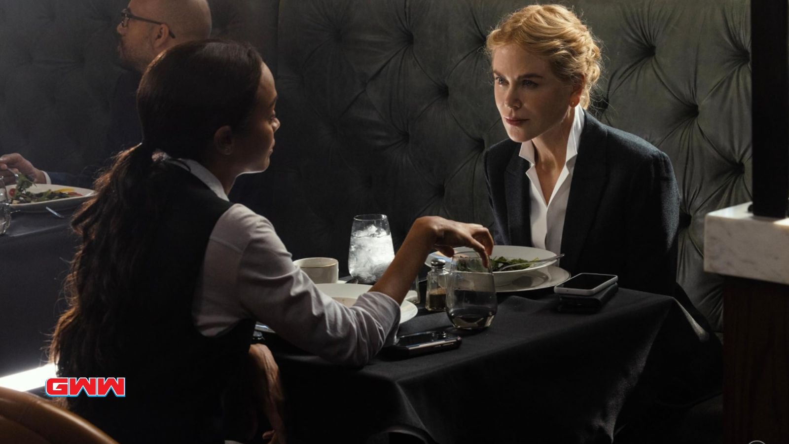 Nicole Kidman as Kaitlyn Meade and  Zoe Saldaña as Joe, one in a suit, discussing at a restaurant table.