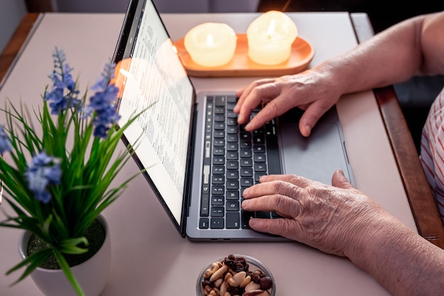 retired woman uses laptop hands close up