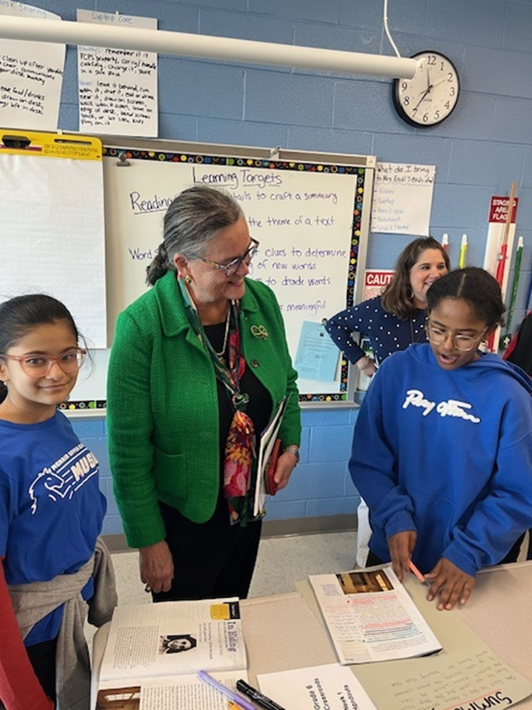 Dr. Reid speaking with two sixth graders working on a language arts assignment at McNair Upper Elementary School. 