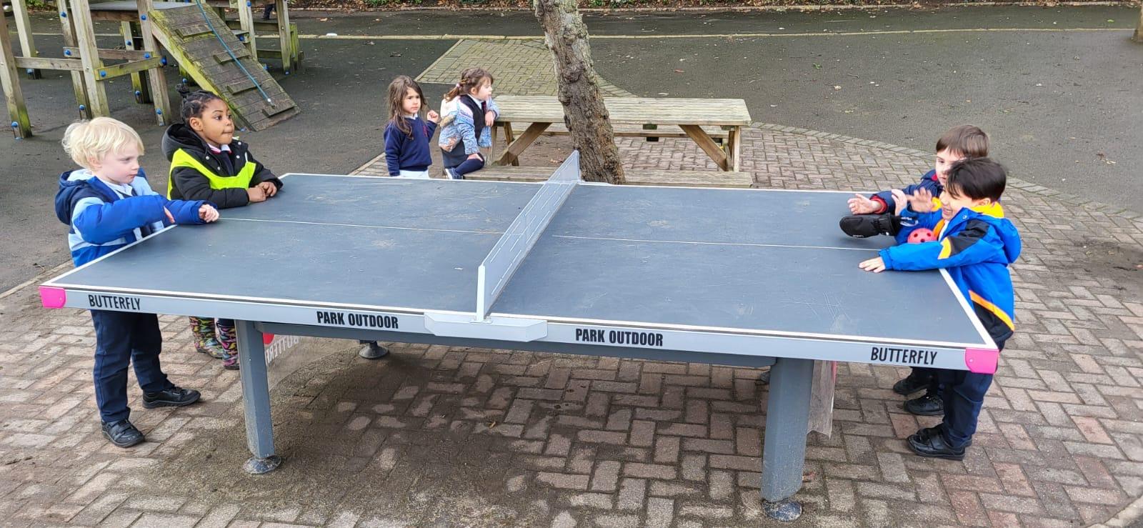 A group of people playing ping pong

Description automatically generated