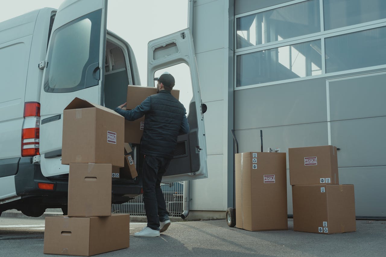 Man loading boxes into a truck, representing efficient freight transport and smart shipping solutions to reduce costs.