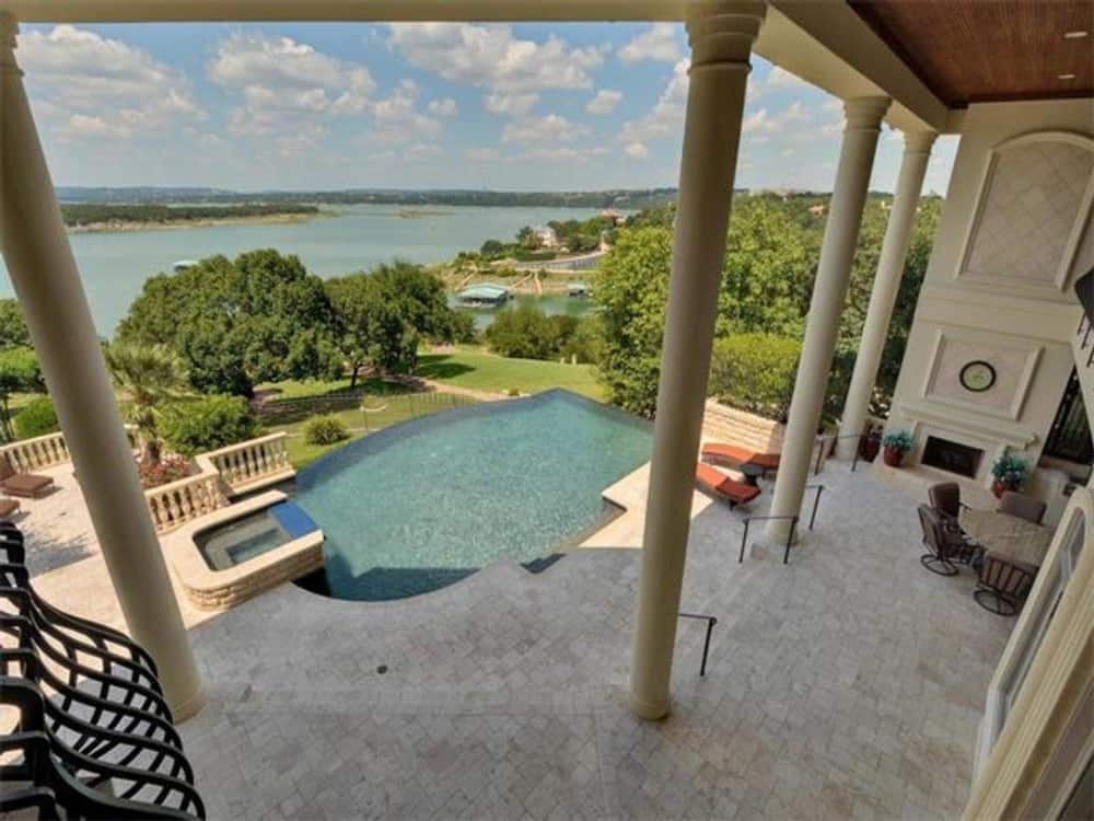 Tall columns border the covered porch and an outdoor fireplace add to the home's curb appeal.