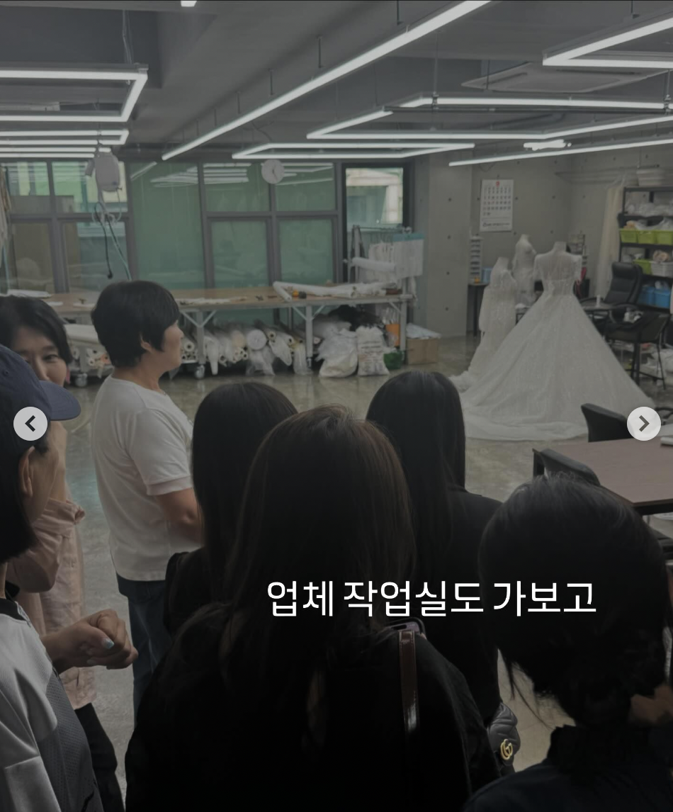 A group of people including Kim Min Kyung standing in front of a wedding dress