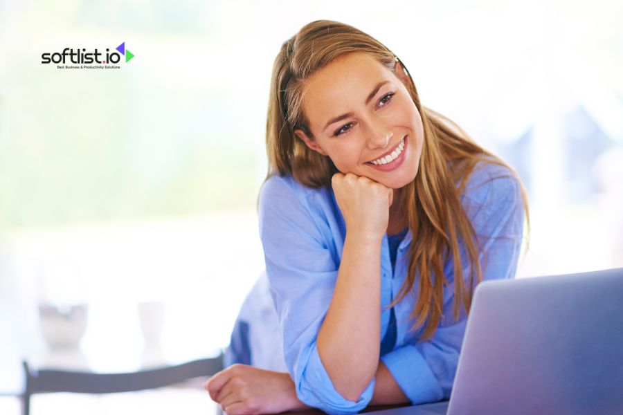 Woman smiling and working on a laptop at home.