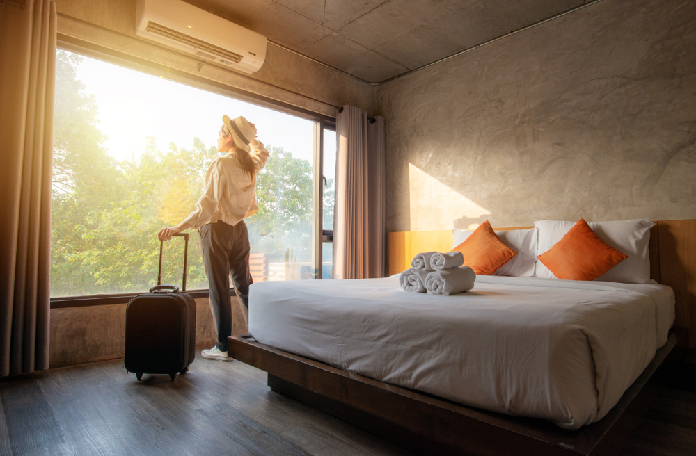 Woman standing in hotel room looking at the view