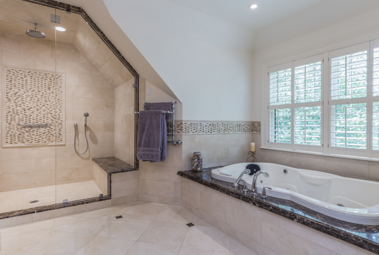 uxurious bathroom featuring a spa tub and glass shower.