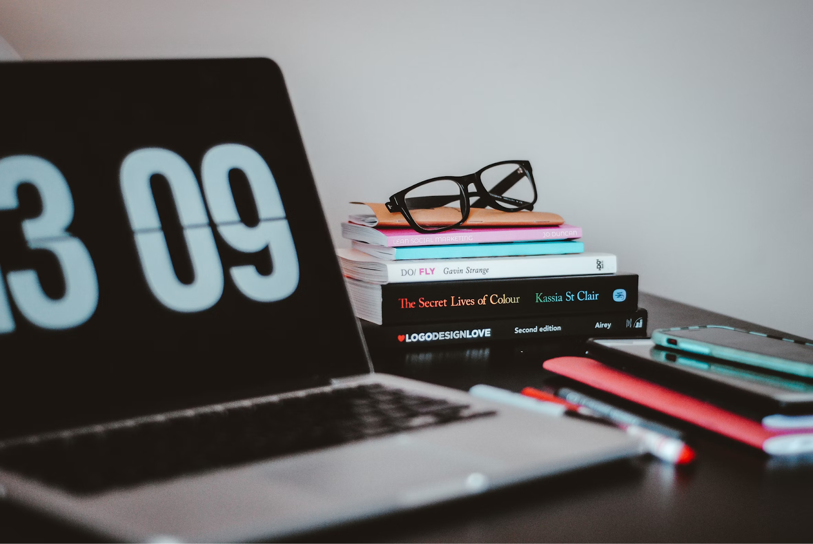 Laptop with time showing and stack of books