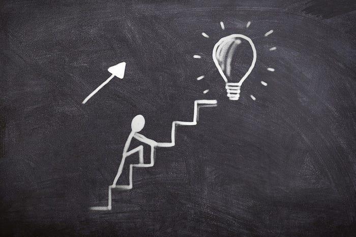 A person climbing up the stairs to a light bulb

Description automatically generated