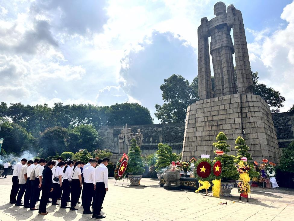 A group of people standing in front of a monumentDescription automatically generated