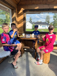 A group of boys sitting at a table Description automatically generated