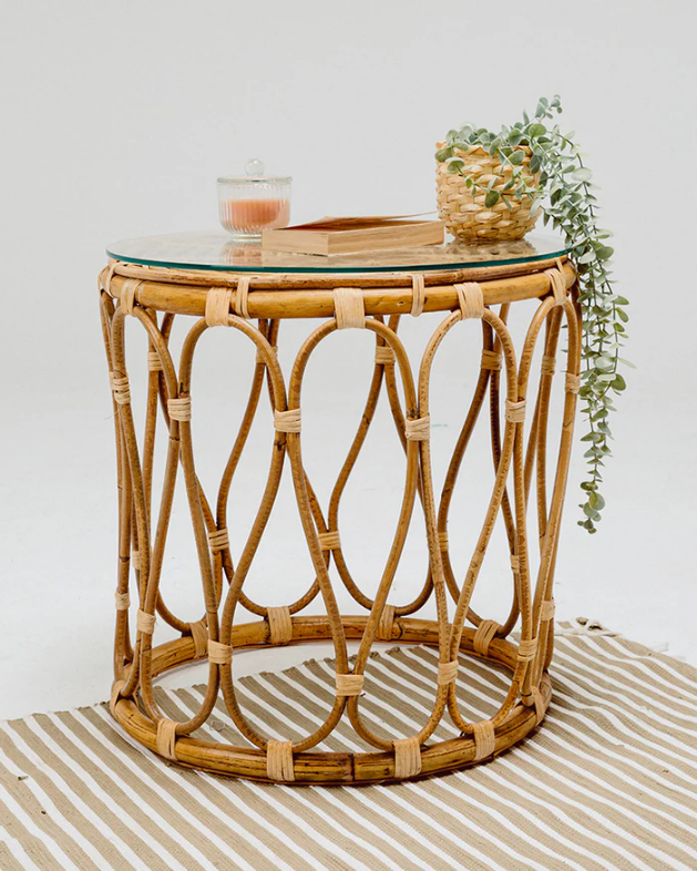 A wicker table with a candle and plant on top

Description automatically generated