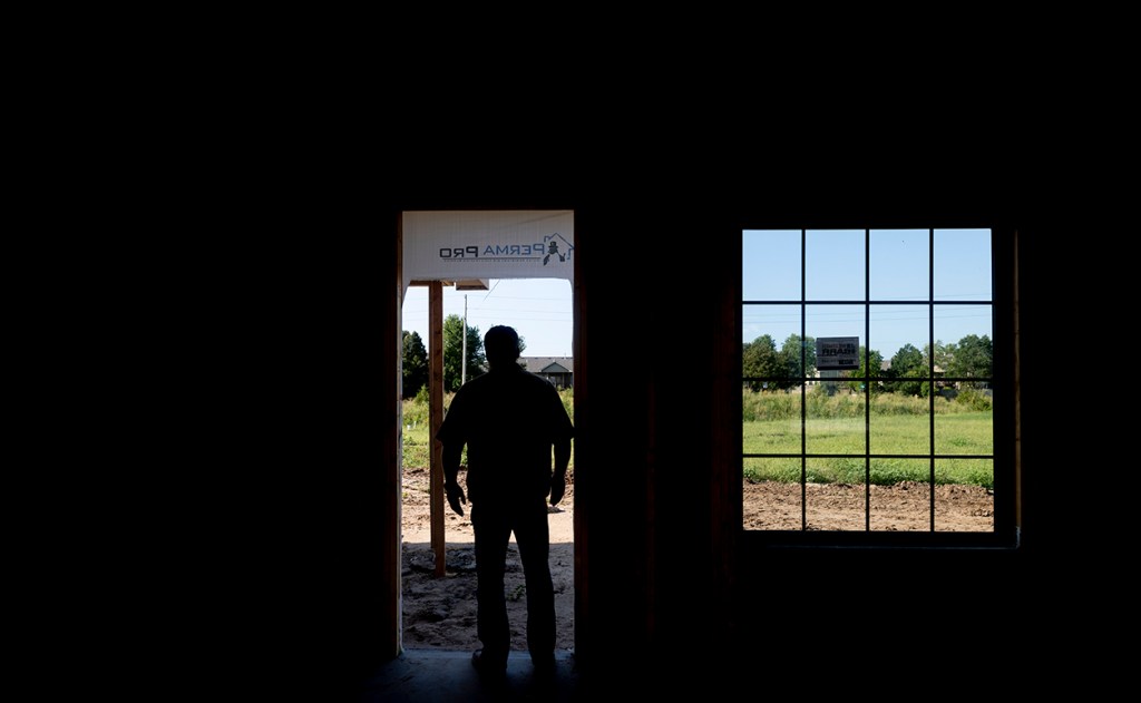 silhouette of man entering house being built