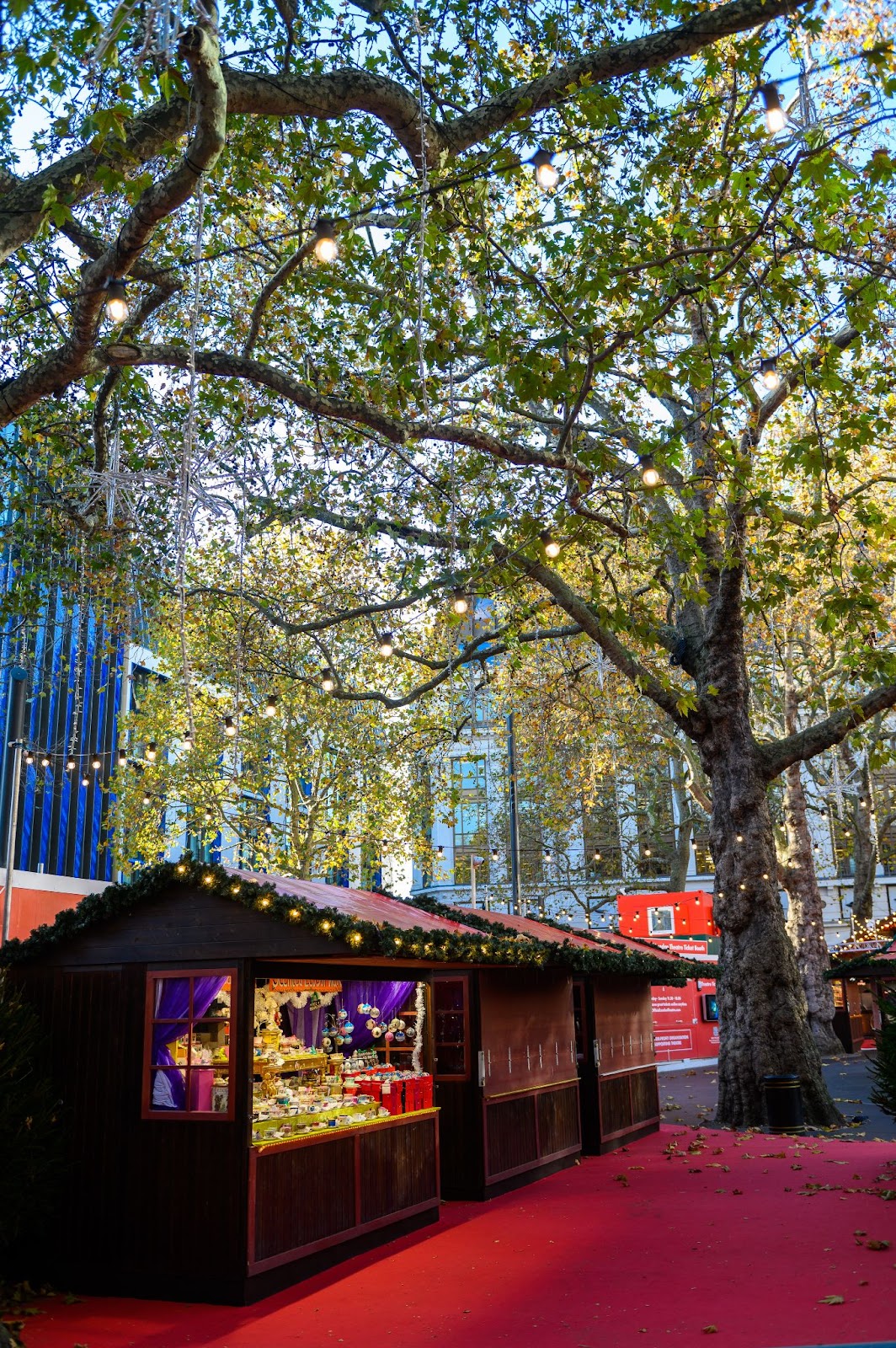 Leicester Square Christmas Market in London with festive stalls, twinkling lights, and visitors enjoying holiday treats and seasonal attractions