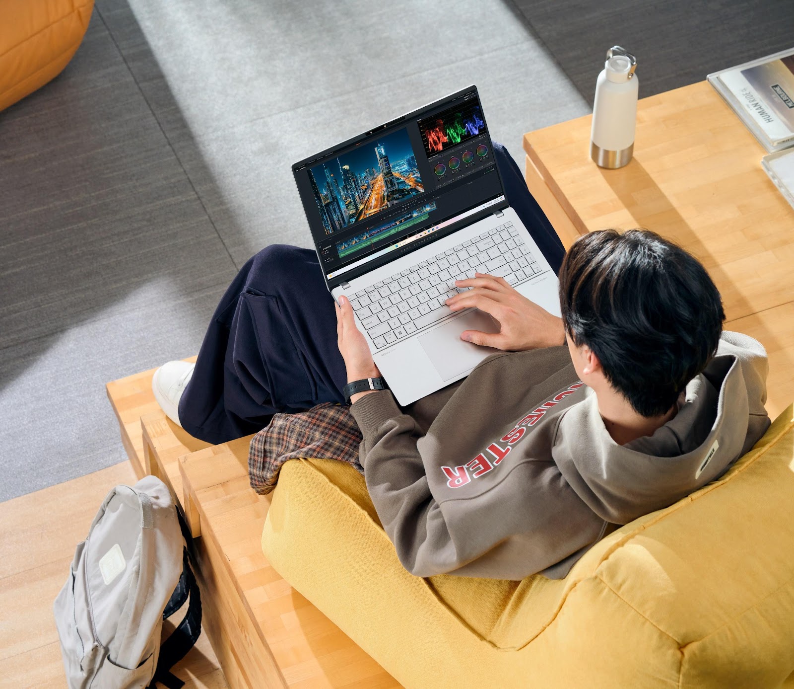 A person sitting on a couch using a computer

Description automatically generated