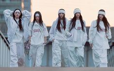 This contain an image of New jean members in white outfits walking down the street