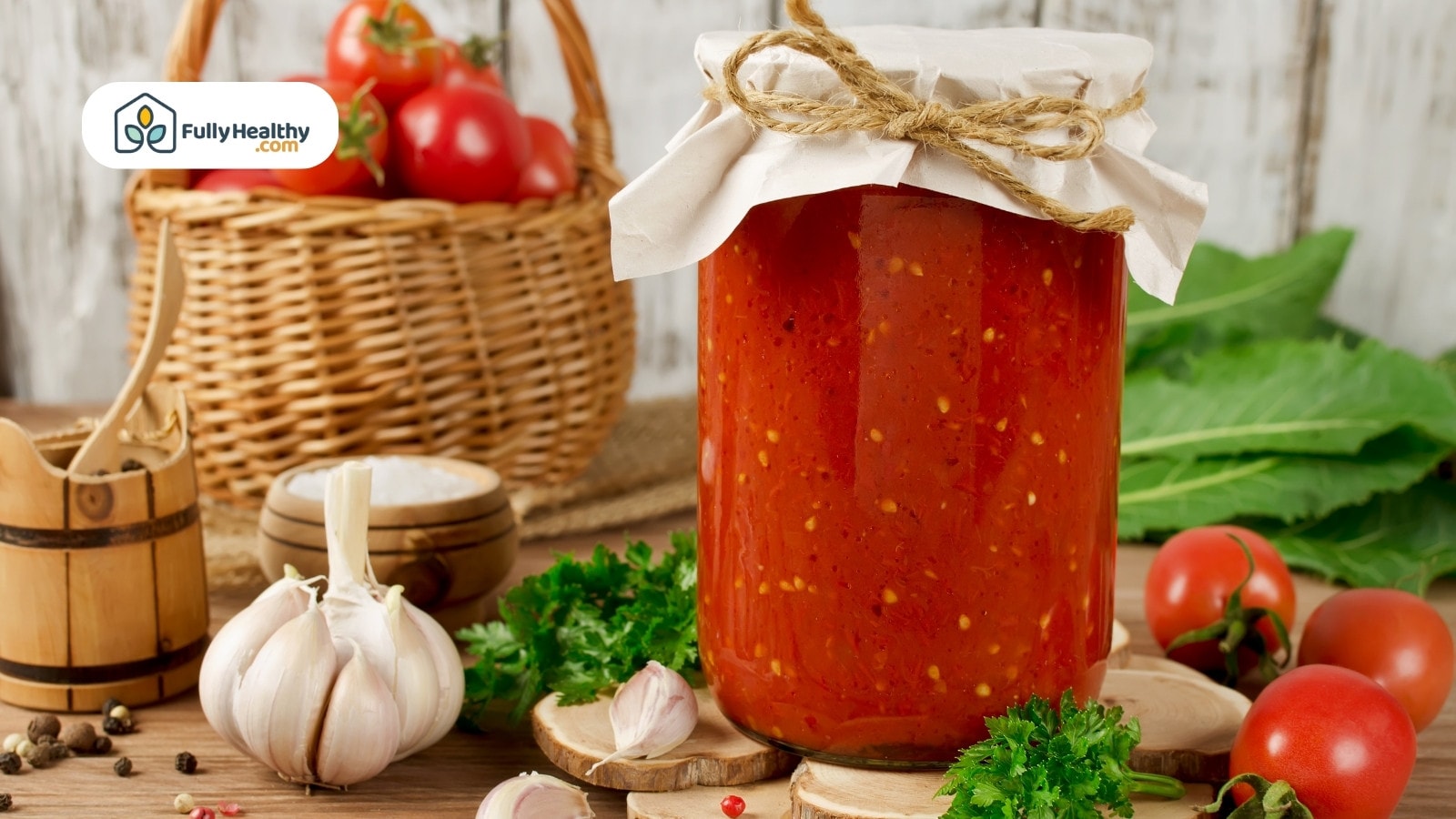 Jar of homemade tomato sauce with garlic and fresh ingredients nearby