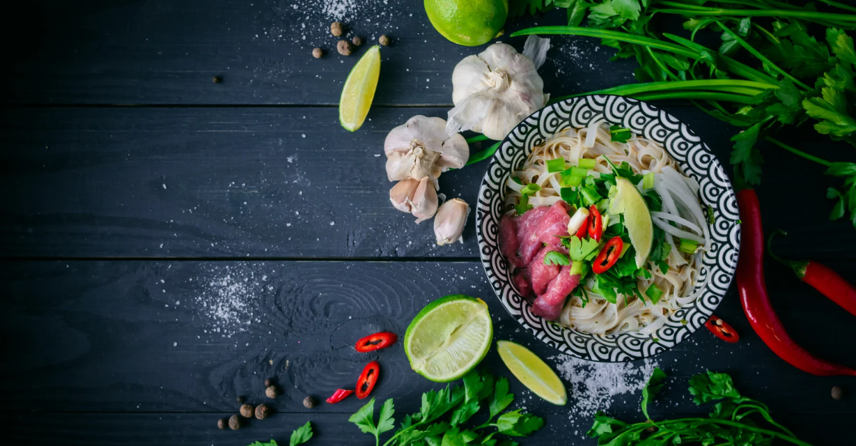 (Schüssel mit Rindfleisch-Pho und Belag drumherum)