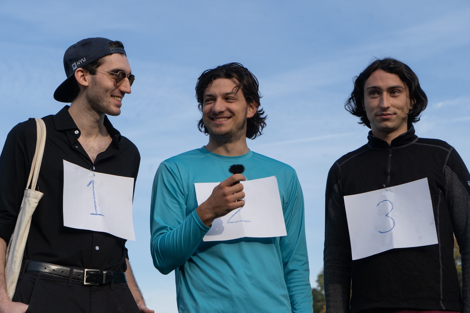 An image of three contestants from the Jack Schlossberg look-alike contest, wearing their number cards.