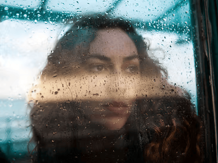 Rain photoshoot featuring a girl behind mirror in black and white theme.