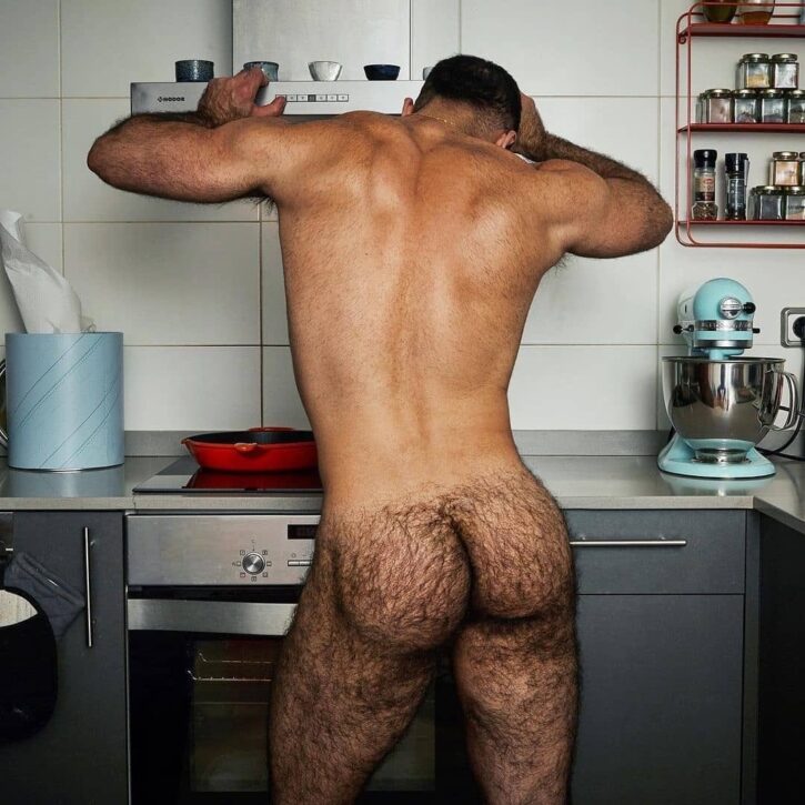 saleh helalat leaning against the stove oven naked in the kitchen showing off his muscled back and extremely hairy bubble butt