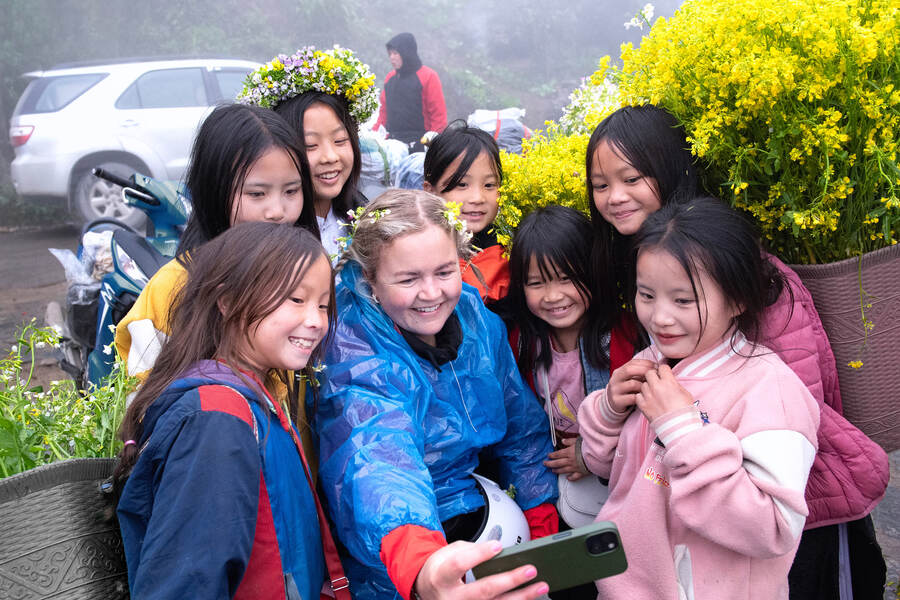 A British tourist takes photos with children on Tham Ma slope (Ha Giang province). Source: happyvietnam.vn 