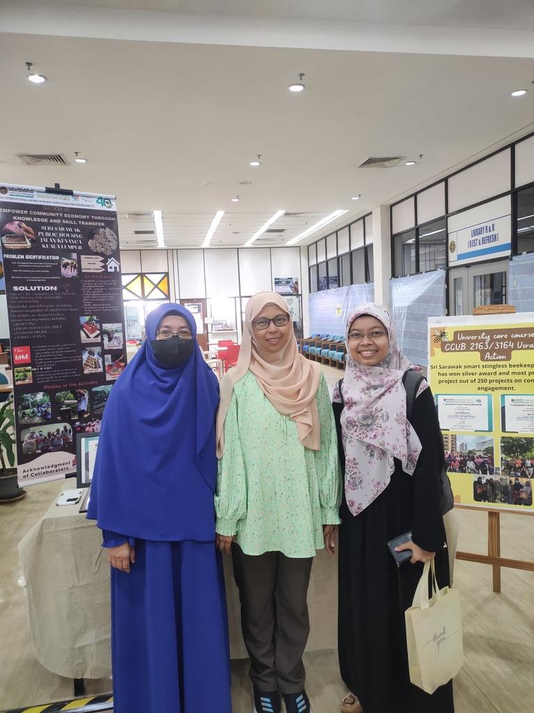 A group of women standing in a room with a poster

Description automatically generated