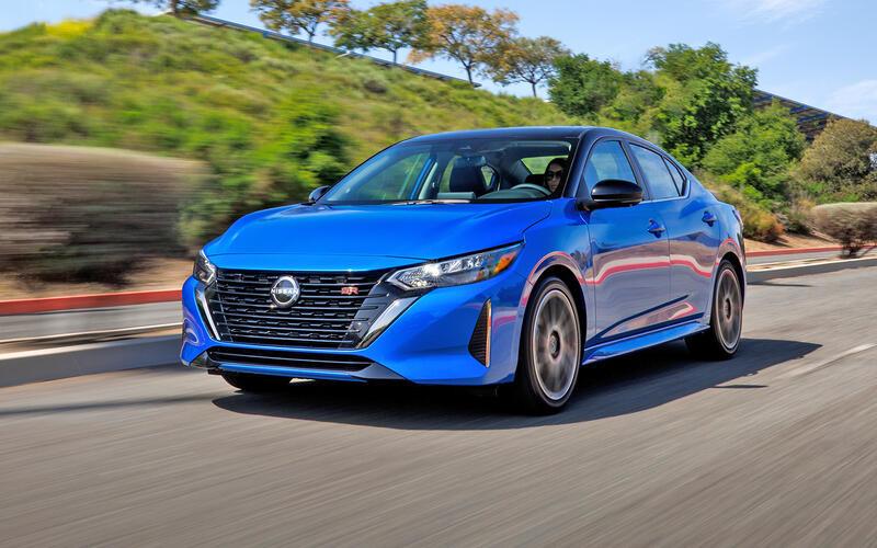 A blue car driving on a road

Description automatically generated