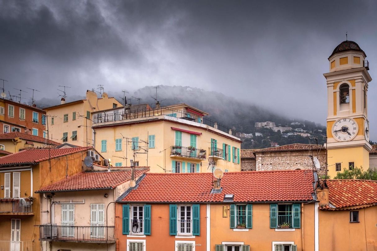 A group of buildings with a mountain in the background

Description automatically generated