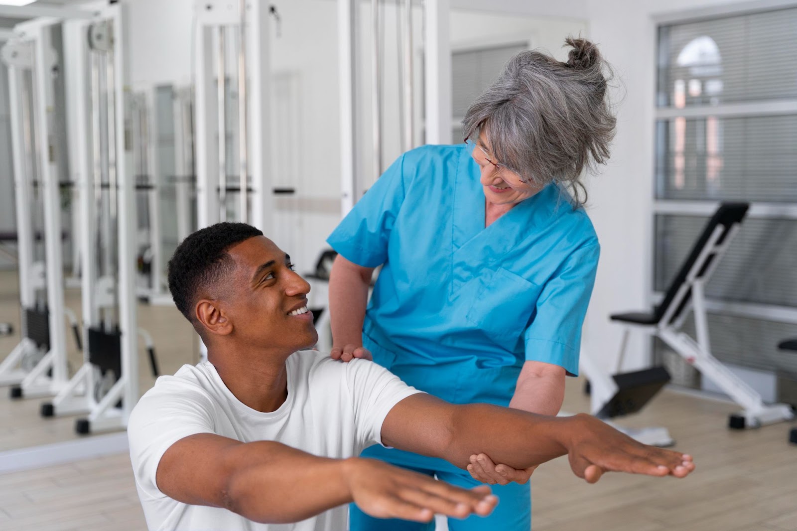 A physical therapist helps a man with an exercise.
