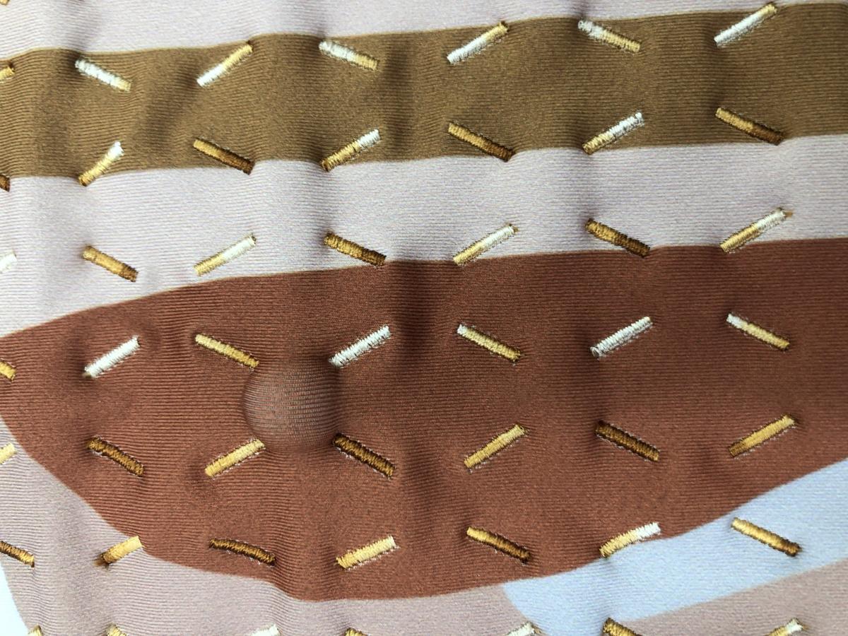 A close-up photo of Deschl's custom-knit garments have a grid stitched into them with small massage balls inside. These balls can be moved onto specific acupressure points on the body, feet, hands and head.