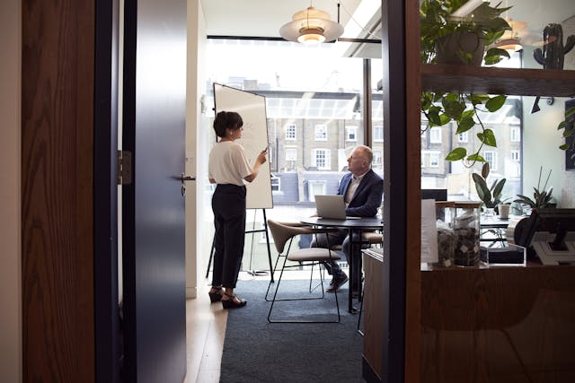 A woman standing in front of a man in an office