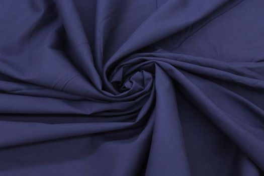 A close-up of a deep dark blue cotton fabric.