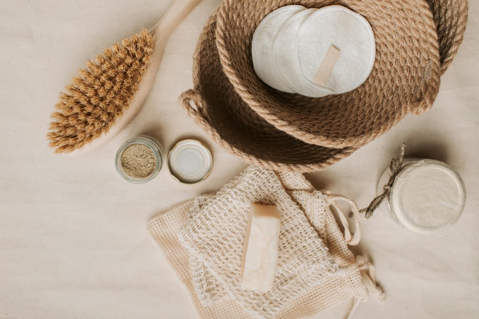 Flat lay of natural bath essentials including a dry brush and handmade soaps in an eco-friendly setup.