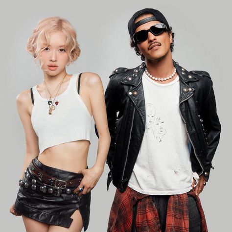 This contain BLACKPINK's Rosé and Bruno Mars standing next to each other in front of a gray background wearing black and white clothing