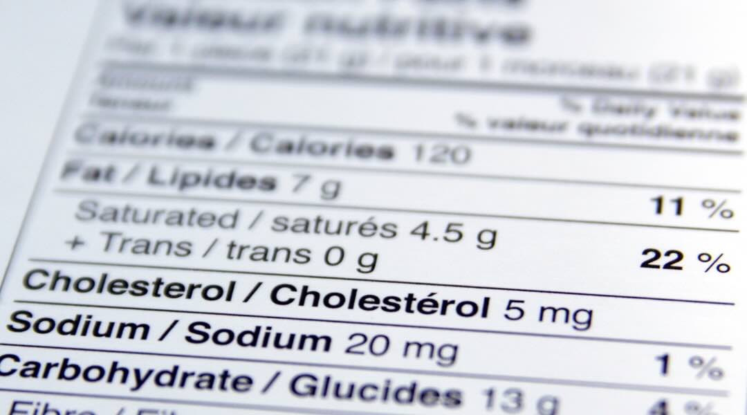 Close-up of a bilingual nutrition label showing fat, cholesterol, and sodium content in grams and percentage of daily value.