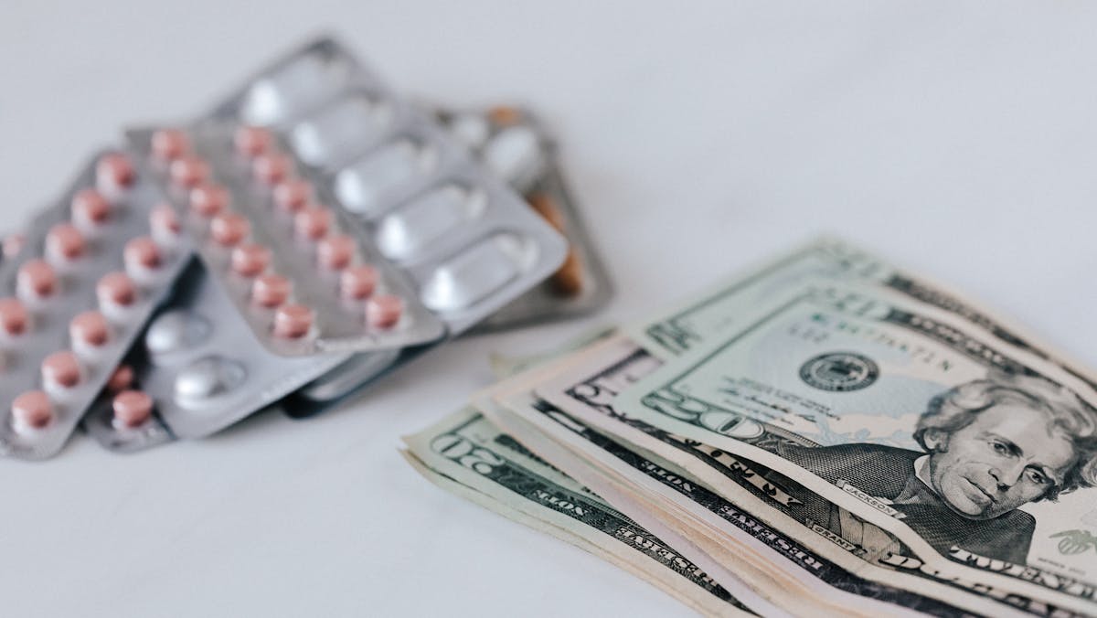 dollar cash beside medicine pills conceptualizing medical expense