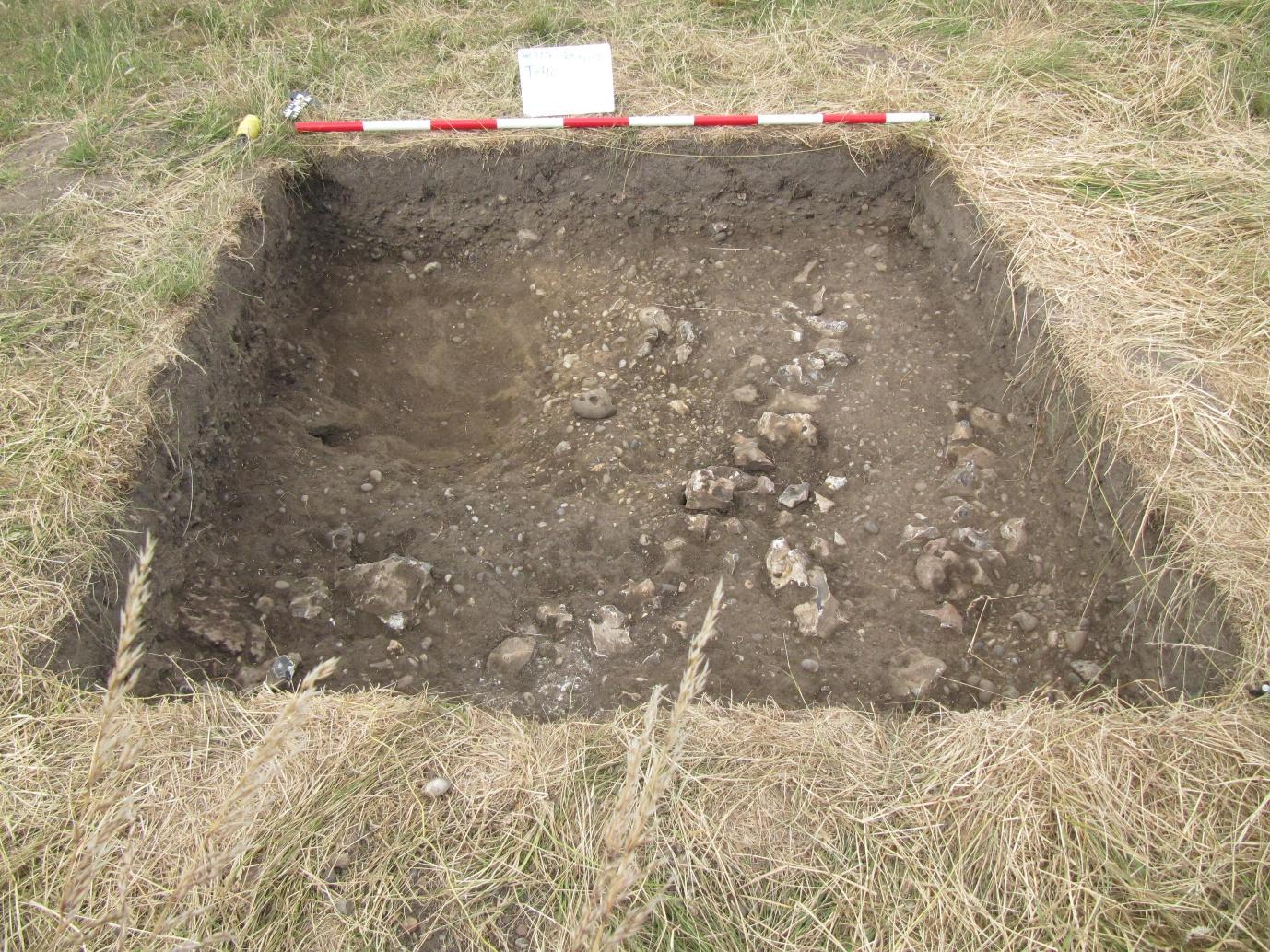 A hole in the ground with a red and white tape

AI-generated content may be incorrect.