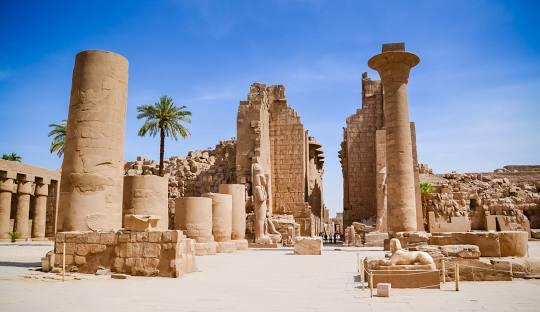 A stone ruins of ancient egyptian city with Karnak in the background

Description automatically generated with medium confidence