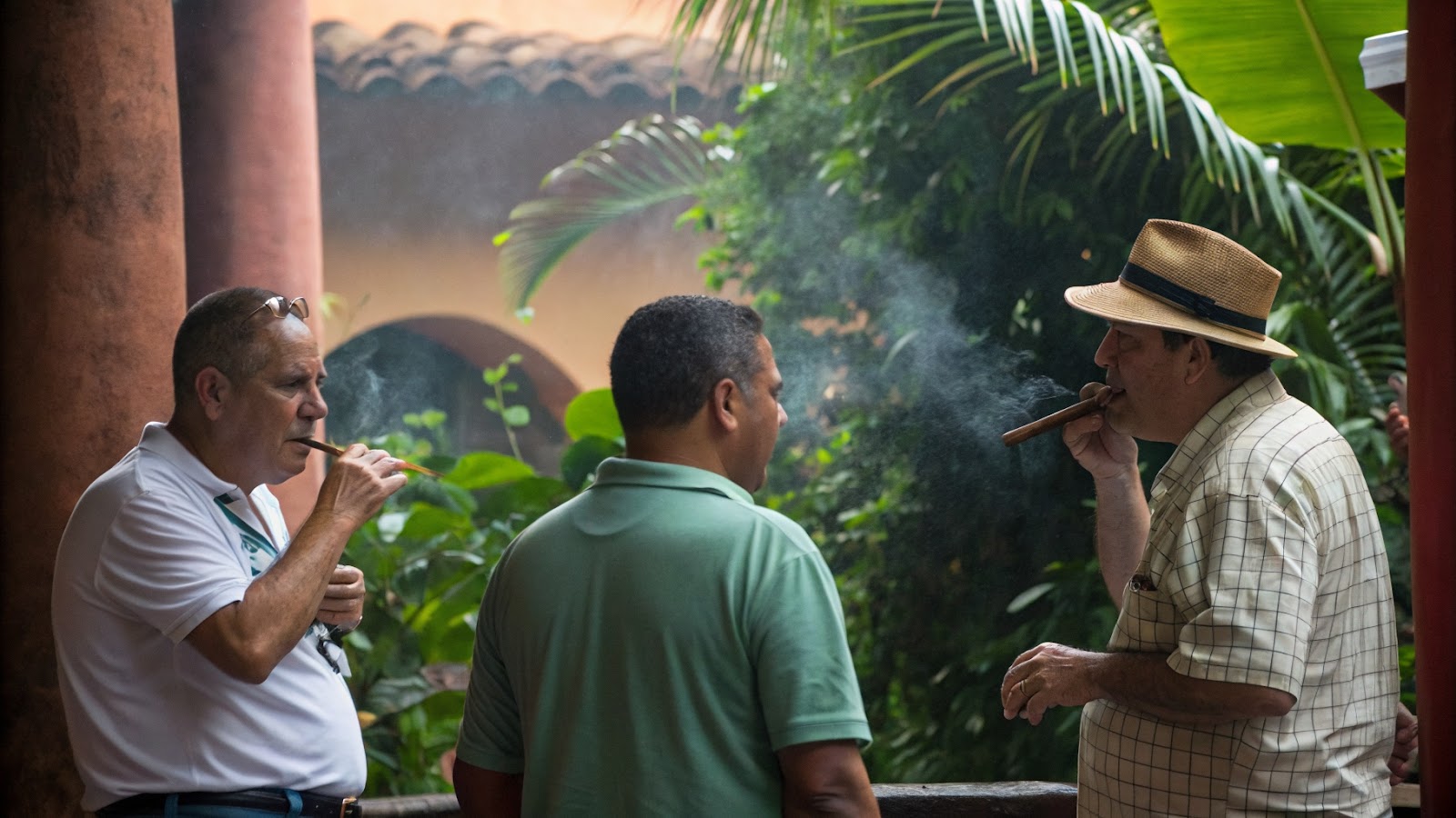Three men smoking cigars outdoors