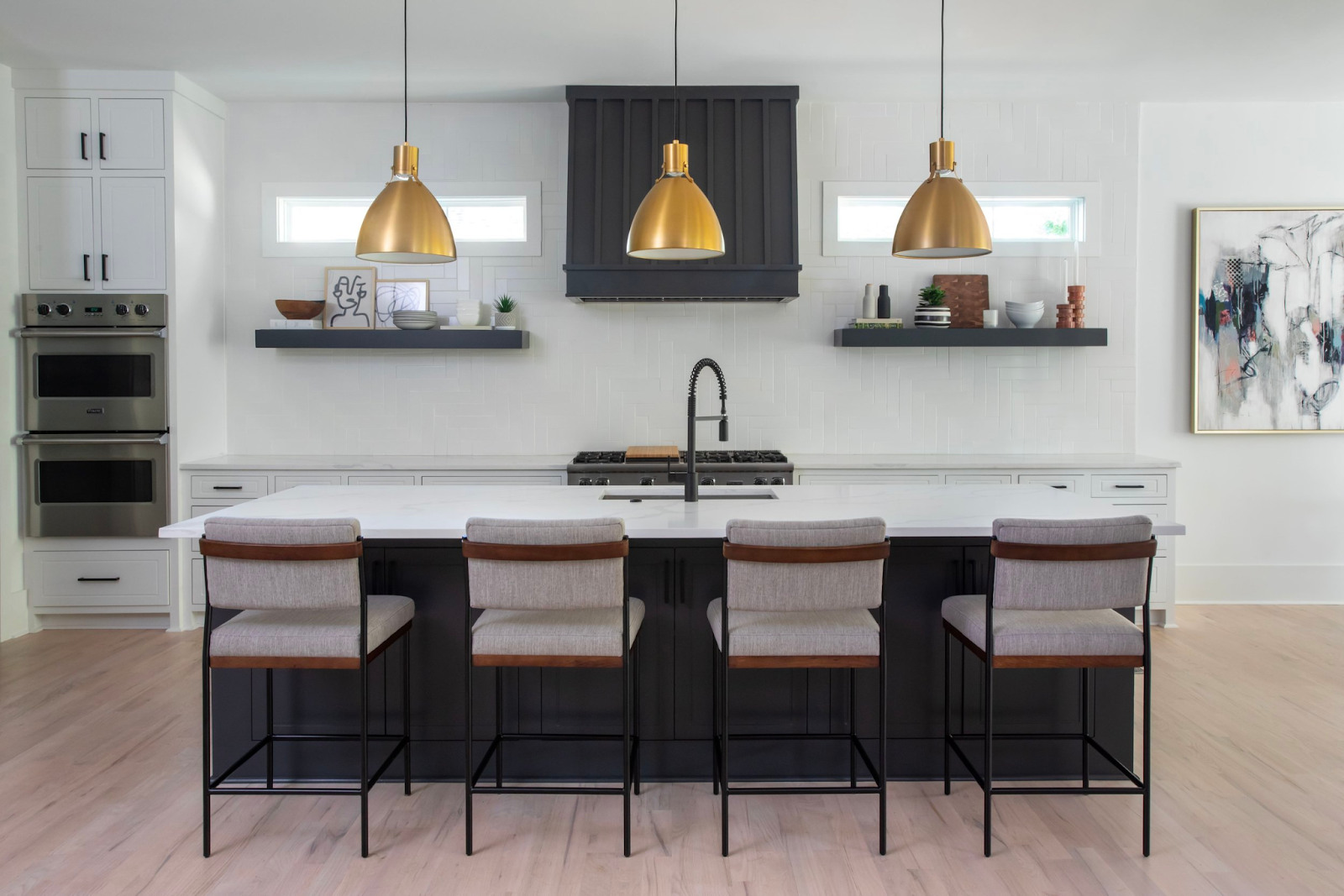 Large, artistic pendant lights hanging over a kitchen island.