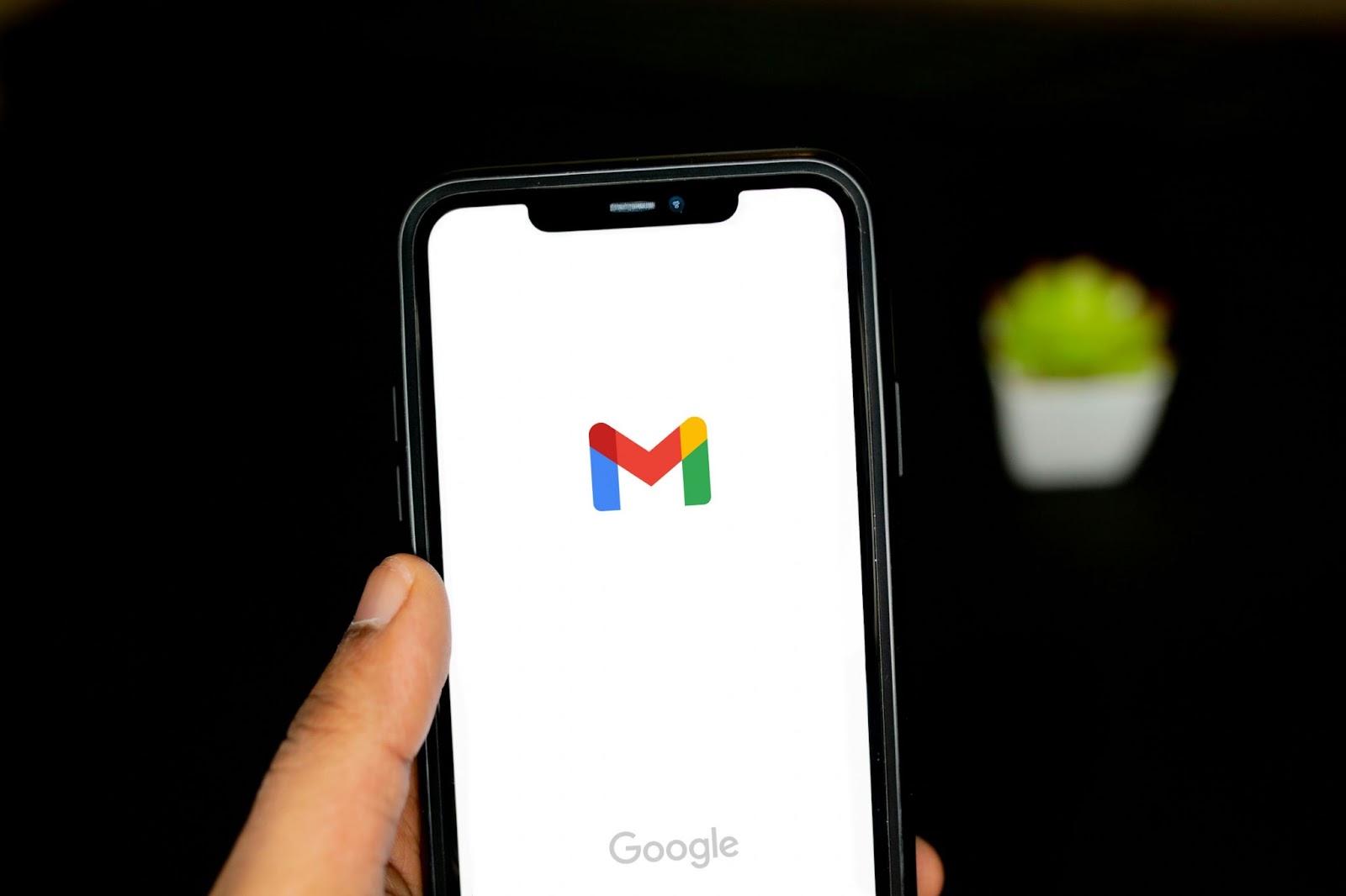 A person holds a smartphone displaying the Gmail logo on the screen checking google forms crypto scam