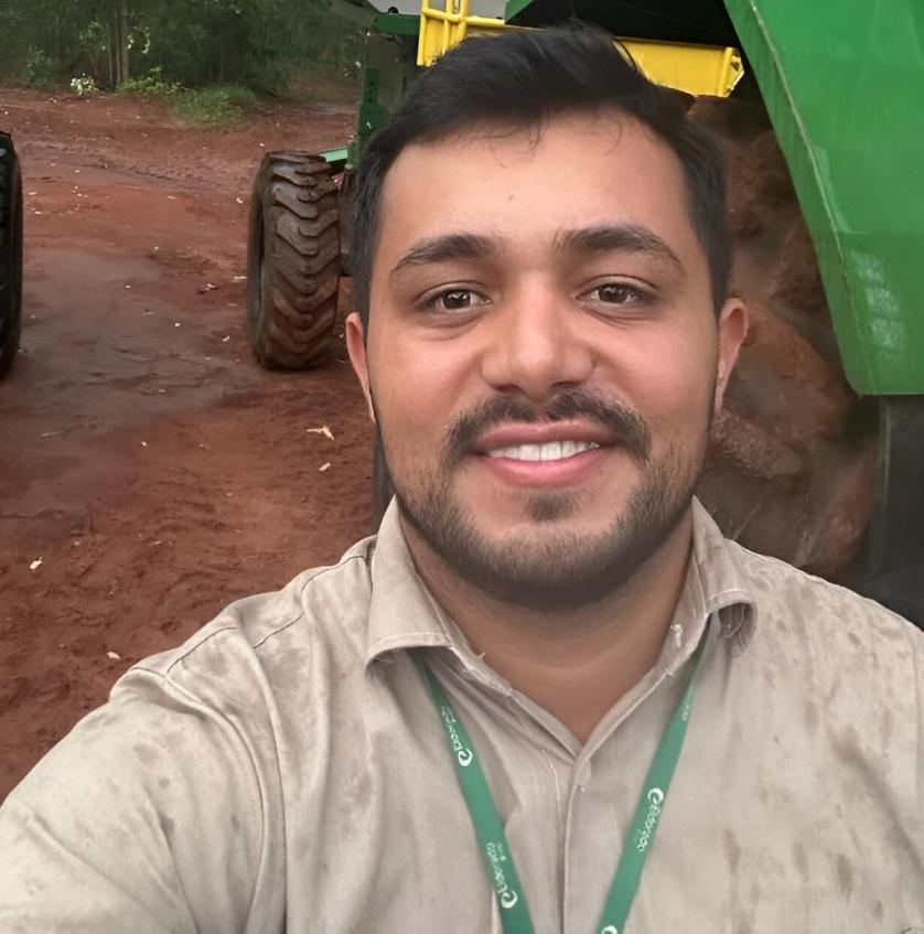 Homem sorrindo com camisa verde
Descrição gerada automaticamente