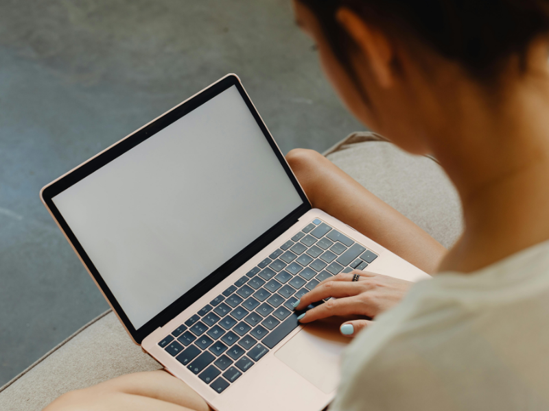 Close-up of a professional accessing an employee portal on a blank laptop screen, symbolizing the start of a digital journey.