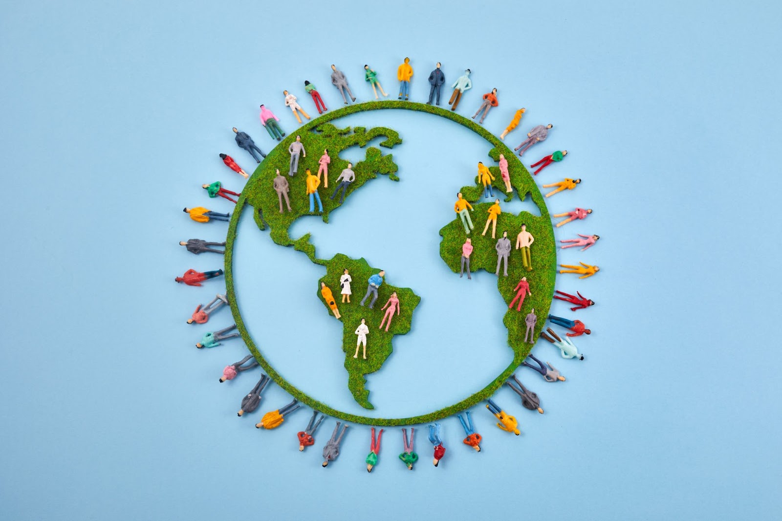 Outlines of people around a model of a globe. 