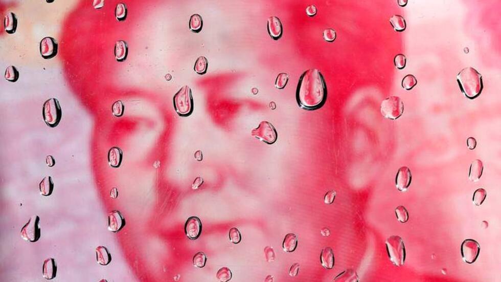 A portrait of former Chinese leader Mao Zedong on a yuan banknote is reflected in water droplets in Taipei in this October 8, 2010 file illustration picture. A Chinese official travelling in Hong Kong