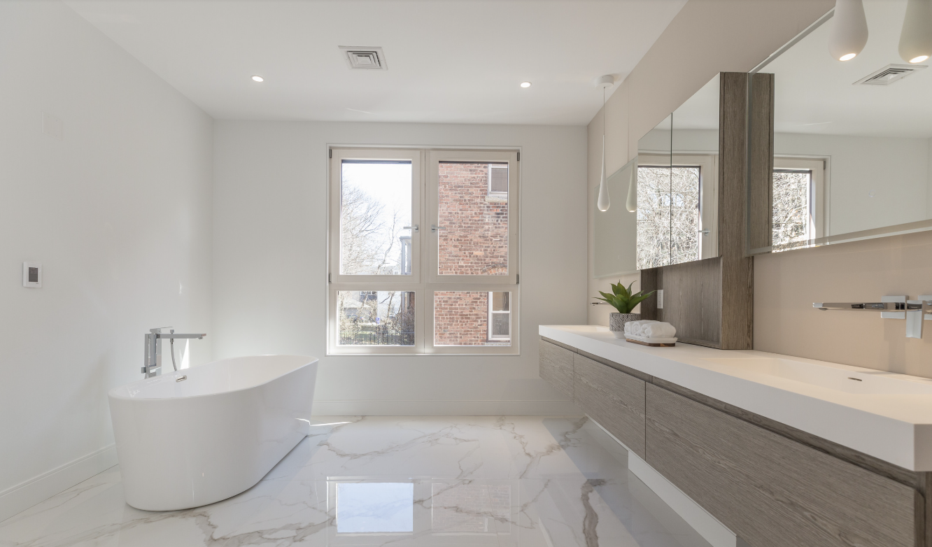 Modern bathroom with freestanding tub and large windows.