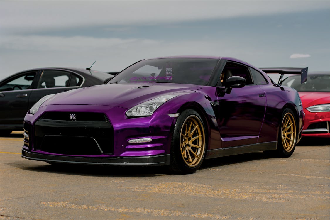 Purple sports car with wide tires sticking out past the fenders