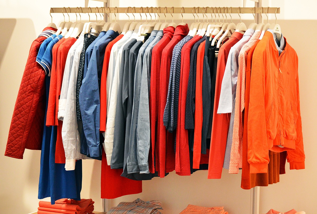 ハンガーラックにかかった赤色やオレンジ、青色の洋服