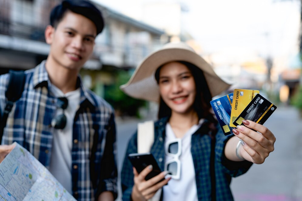 A person and person holding credit cards and a map  Description automatically generated